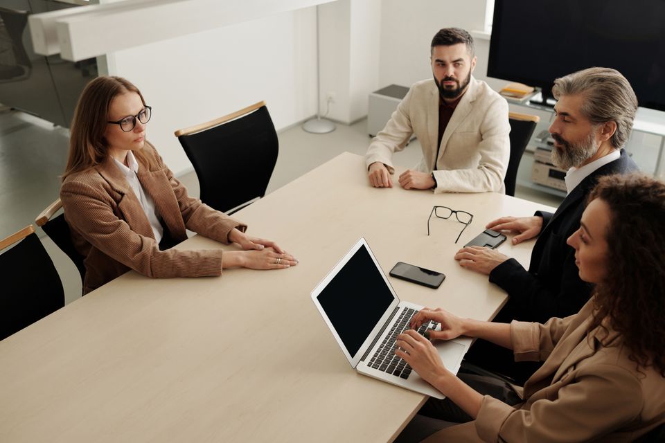 Professionals discussing plans around an office meeting table